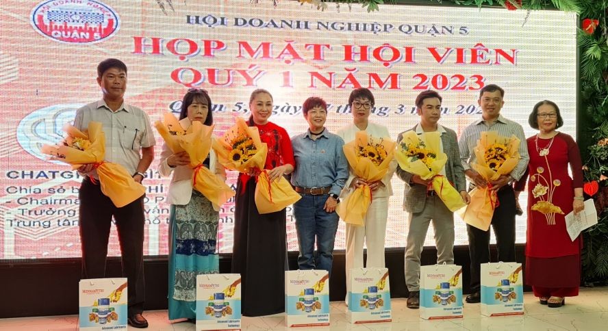 第五郡商会主席苏慧兰（左四）向新会员送花送贺。