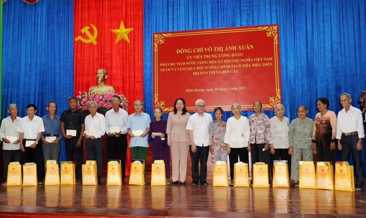 国家副主席武氏映春（中）向平阳省滨桔市优抚政策对象赠送礼物后合影留念。（图：人民报）