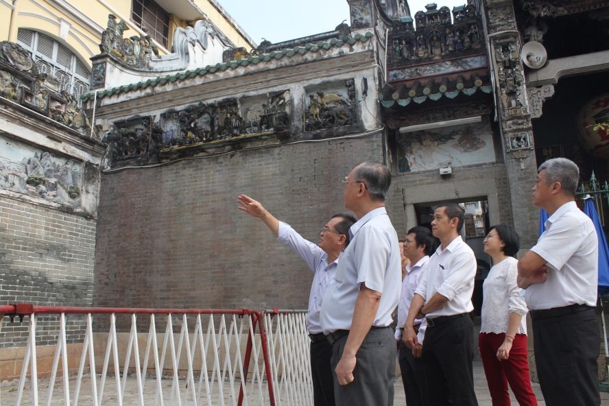 建筑单位代表向穗城会馆理事会介绍修葺浮雕和墙头画的步骤。