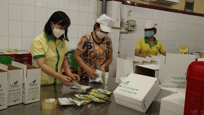   Vianco联营企业质量管理部门主任武氏海党员（左一）正检查产品质量。