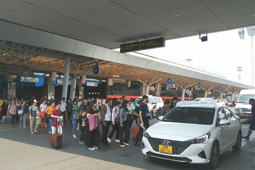 人流横跨新山一机场的汽车道。