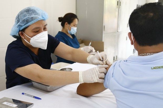 医护人员在为一名男性施打新冠疫苗。（图：越通社）