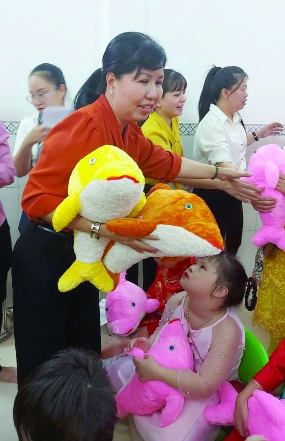 第五郡妇联会主席陈氏雪幸向残疾少儿赠送毛公仔。