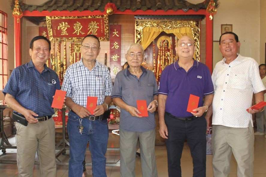 毕氏宗祠理事长毕景焯（右一）向诸位长者赠送敬老利是。