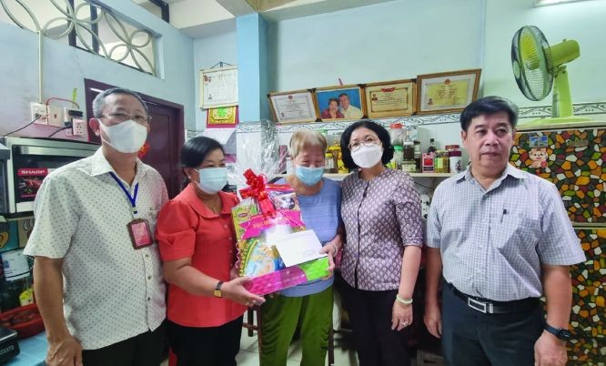 第五郡郡委书记黄玉女芳红(右二)看望华人革命有功者何金惠大娘。