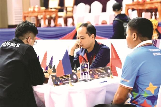 越南选手武成宁(中)在高棉象棋赛项上与菲律宾选手角逐。（图：越通社）