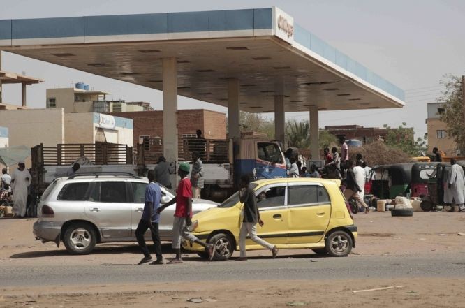 苏丹冲突持续，民众在一个油站等候领取物资。（图：AP）