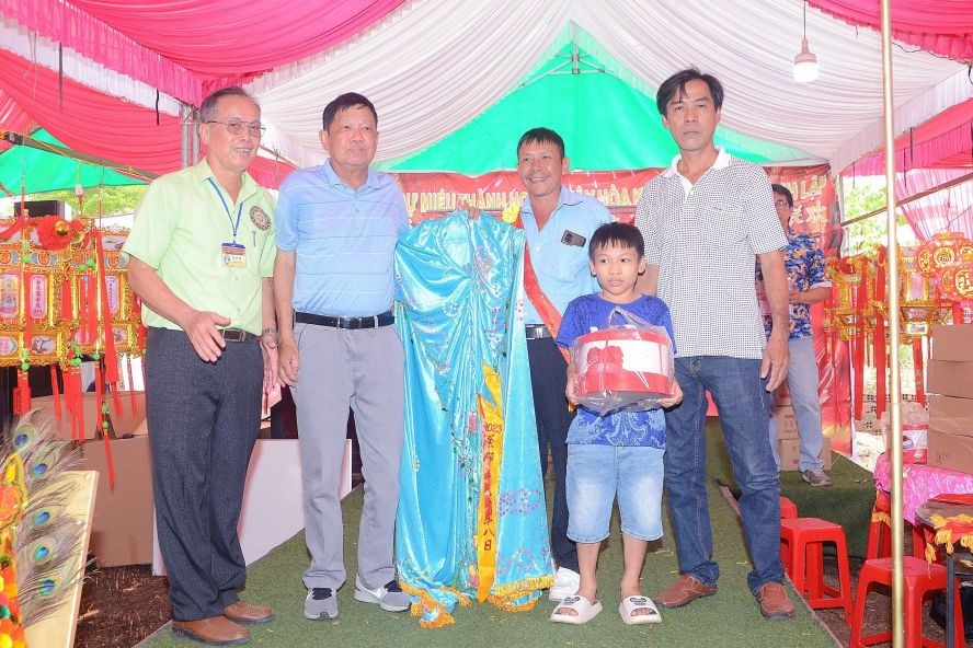 同奈省展邦县宝超城隍、观音庙理事会代表向黄泽邦先生（左二）移交“观音菩萨袍”。