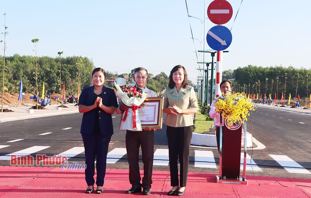 平福省领导向捐地修路的阮友待大伯（右二）转交政府总理颁授的奖状。（图：平福在线）