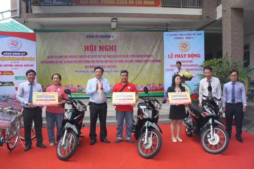 该坊领导和茶山庆云南院住持周华邦（右二）向贫困者赠送摩托车。