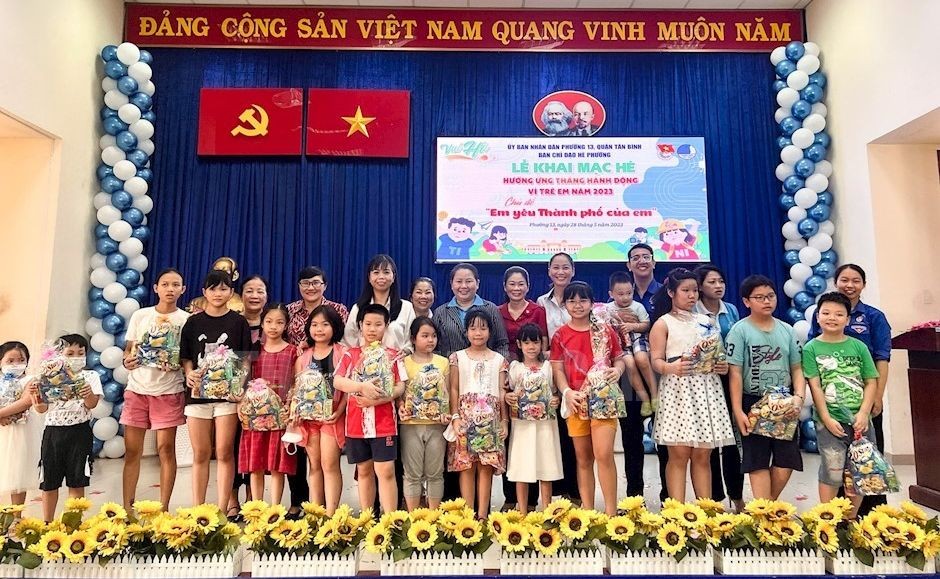 市劳动联团与新平郡领导为当地少儿派发礼物并合影。（图：市党部新闻网）