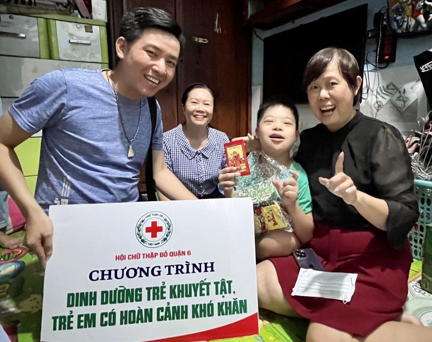 由红十字会主席黎氏宝庄（右）与代表团给俊英弟弟赠送礼物，他十分高兴。