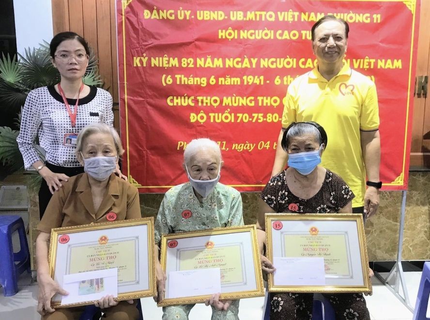 第十一郡高龄人会主任朱杞文（右一）和坊祖国阵线委员会主席范杭降秋（左一）向越华老人贺寿。