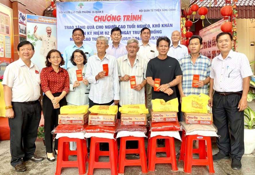 第十六坊代表和崇正慈善会理监事向贫困老人赠送礼物。