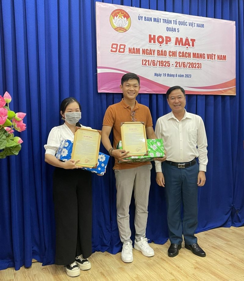 郡越南祖国阵线委员会主席黎晋才向本报记者林珮珮赠送感谢状。