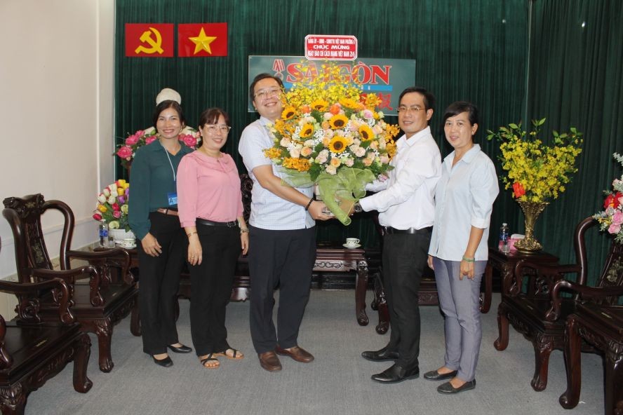 第六坊人委会主席武明哲向本报编委文忠孝赠送鲜花。