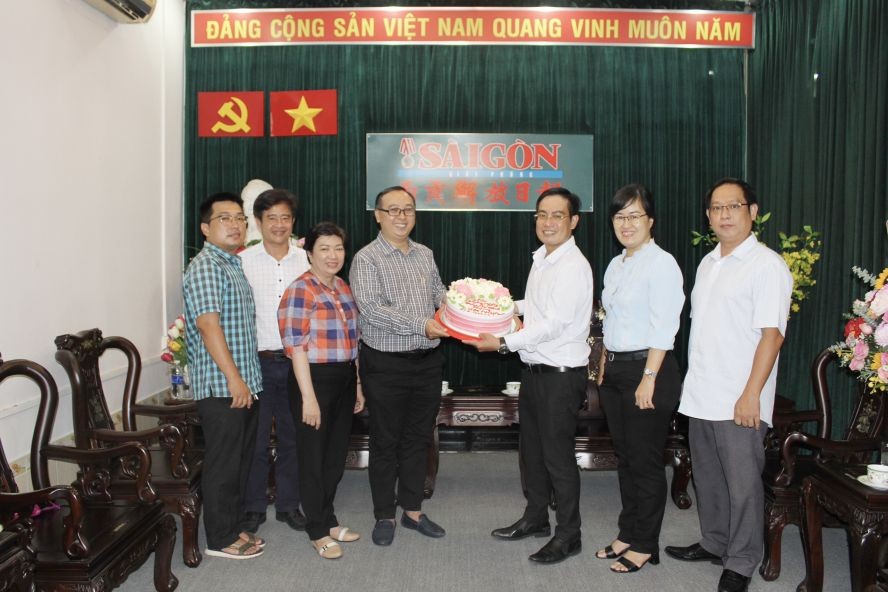 第十坊常务副书记陈德谦向本报编委文忠孝赠送蛋糕。