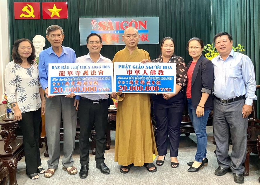 释慧功上座（右四）与陈健安副会长（左二）代表各把2000万元转交于本报编委文忠孝（左三）。