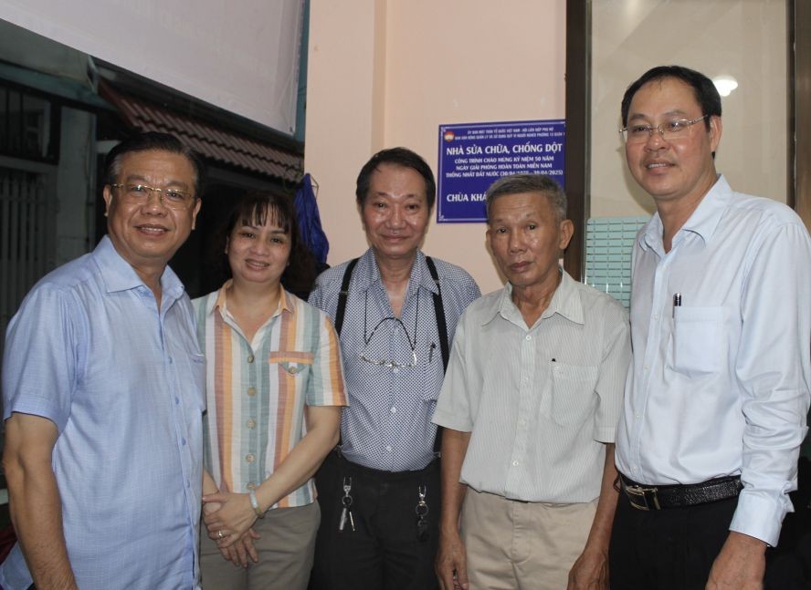 市越南祖国阵线委员会常务副主席阮成忠（右一）和庆云南院住持周华邦（中）与地方领导向裴文春一户移交温情屋。