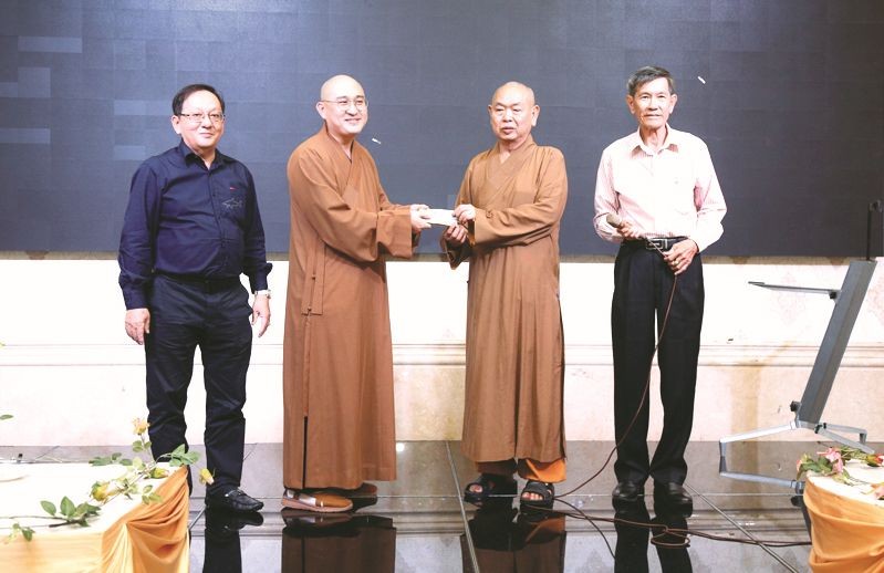 第八郡红十字辅助会会长释慧功法师接受释通振法师捐献的善款。