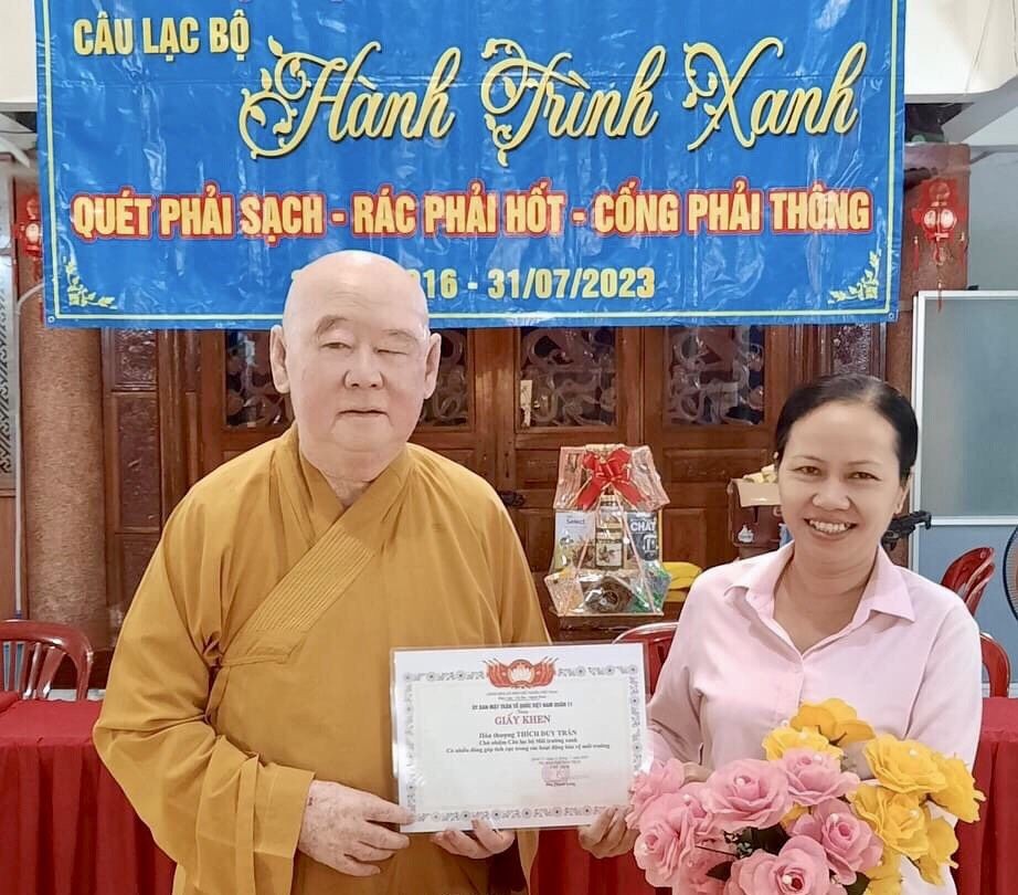 第十一郡越南祖国阵线委员会副主席黎氏秋云向莲华寺住持、“绿色环保”俱乐部主任释惟镇法师颁发奖状。