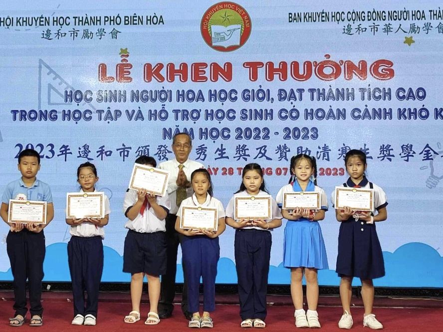 边和市华人励学会主任黄有义向华人子弟颁奖。