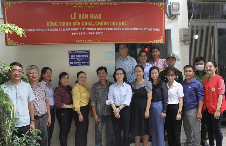 华文《西贡解放日报》和郡、坊领导向华人荣军移交“情义屋”。