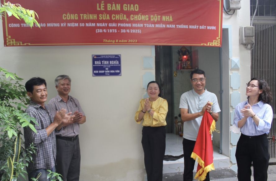 华文《西贡解放日报》和郡、坊领导向华人荣军移交“情义屋”。