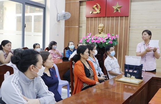 第十二郡社会政策银行干部为民众指引办理优惠贷款手续。