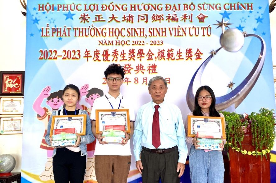 崇正会馆理事长郑鑫发向大学生颁奖。