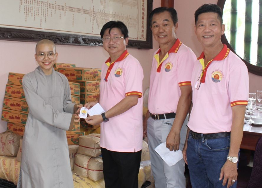 郑氏宗祠理事会诸位代表向安平寺孤儿院代表移交盂兰节济贫礼物。