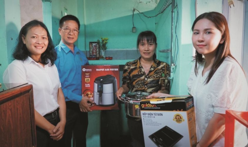 平盛郡劳动联团和赞助商代表向苏氏芳（右二）赠送炊具。