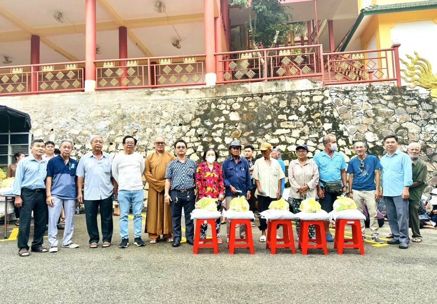 崇正天后宫理事长邹国荣（左六）与各理监事、赞助商等向穷人赠送礼物。