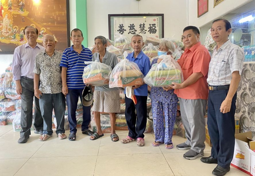 福慧慈善组代表、来宾与赞助商赠送礼品予穷人。