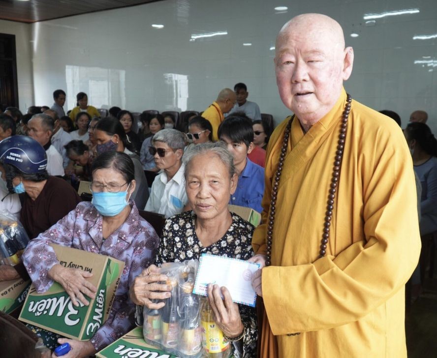 第十一郡莲华寺住持释惟镇法师向少数民族同胞派发礼物。