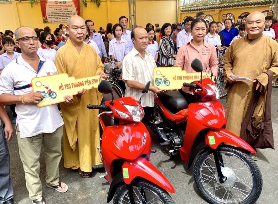 第八郡郡委副书记杜友智（左三）、龙华寺住持释慧功（左二）和常光寺院主释真静（右一）向贫民赠送摩托车。