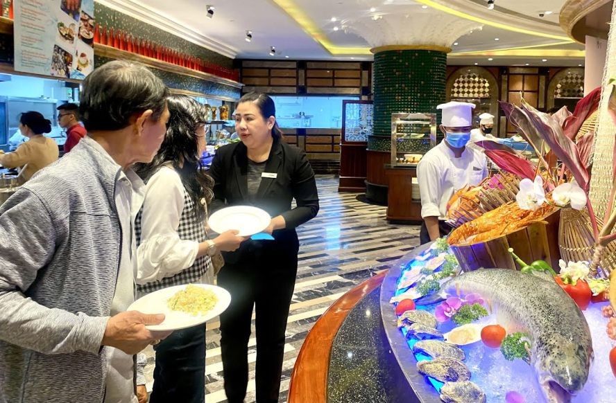 溫莎自助餐服務員向食客介紹烹飪各道海鮮的美食。