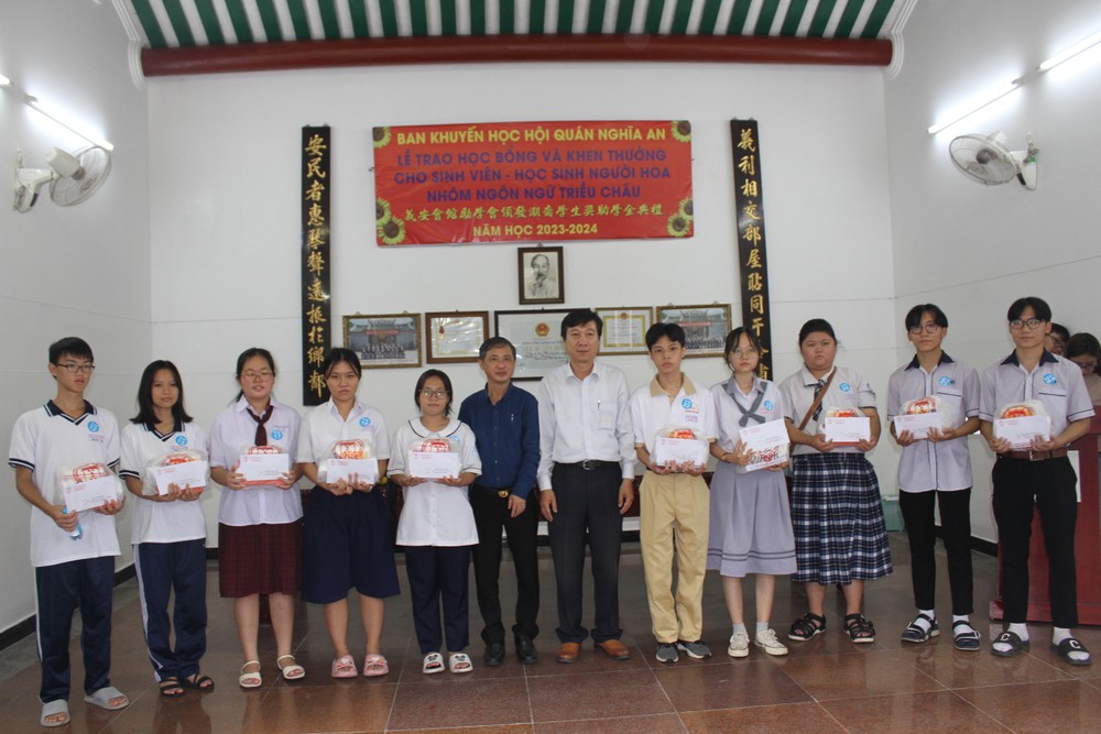 义安会馆委员陈浩永和罗国均向优秀子弟颁奖。