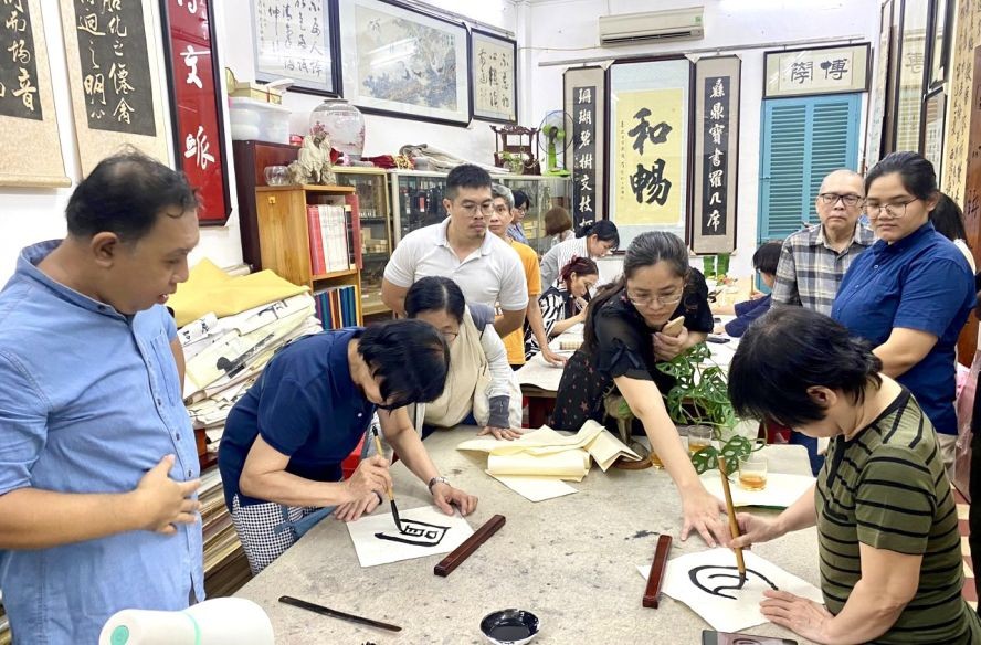 学生们在中秋聚会上应节挥毫。