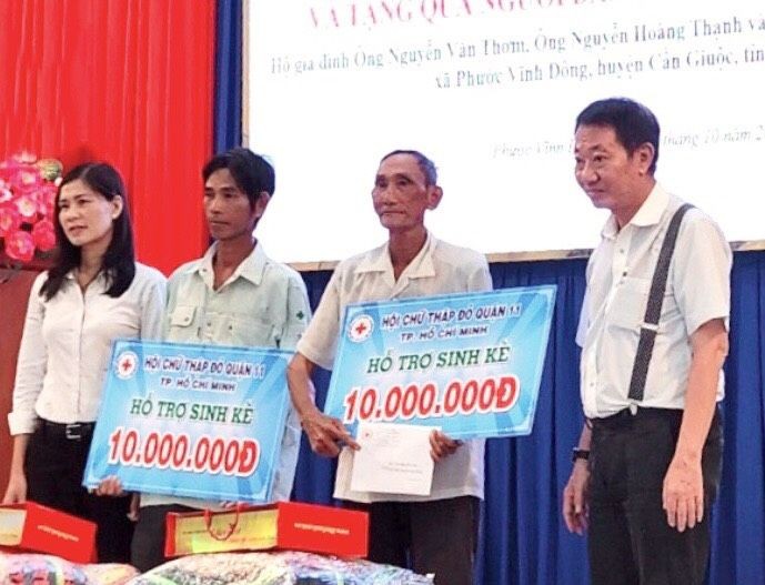 茶山庆云南院住持周华邦（右一）向贫困渔民赠送生计。