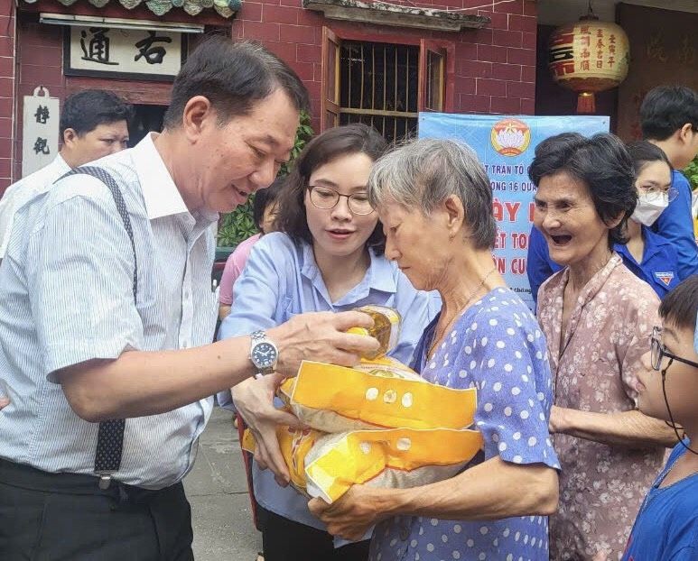 茶山庆云南院住持周华邦向贫困者赠送礼物。