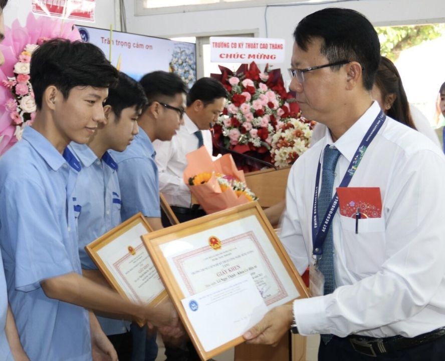 雄王职技学校党支部书记副校长阮玉幸向优秀毕业生颁奖。