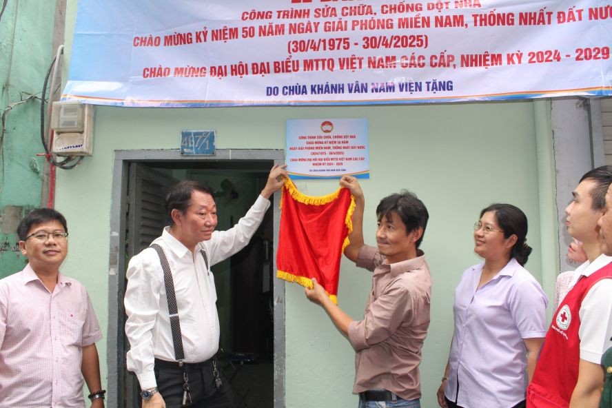 第十一郡第十一坊领导和庆云南院住持周华邦向贫困户移交修缮“温情屋”工程。