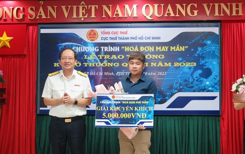 市税务局副局长阮进勇向2023年第二季“幸运发票”计划得奖者颁奖。