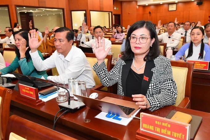 图为市人民议会第十二次会议代表举手表决通过《决议》。（图：越勇）