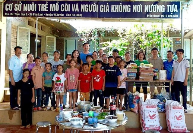 杨显单位正抚养三十名儿童和照顾两位孤寡长者。阮文面老师站在左一。