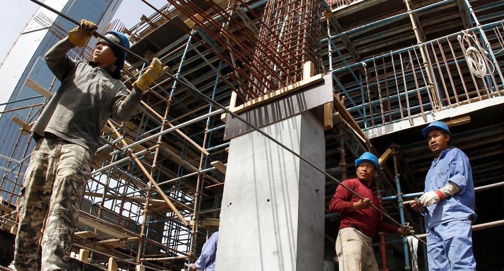 卡塔尔一处建筑工地上，移民工人在搬运钢筋。（图：联合国）