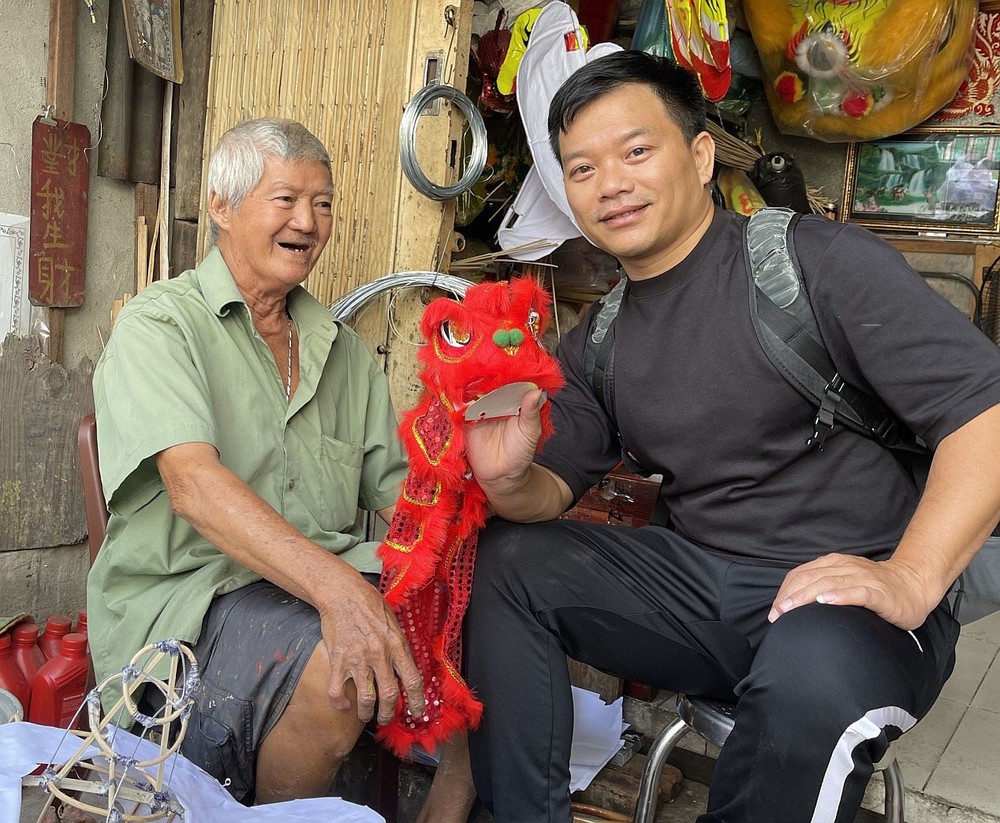 湛德兴（左）向笔者赠送他精心扎作的舞狮纪念品。
