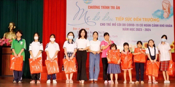 学生们在守德市妇联会举办的“义母”感恩活动中领取礼物。