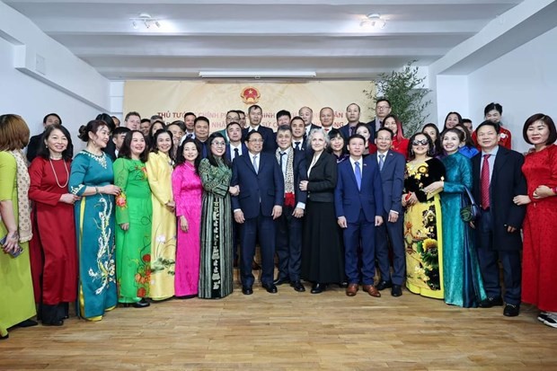政府总理范明政和夫人与驻罗马尼亚大使馆干部和工作人员以及旅居罗马尼亚越南人社群代表合影。（图：越通社）